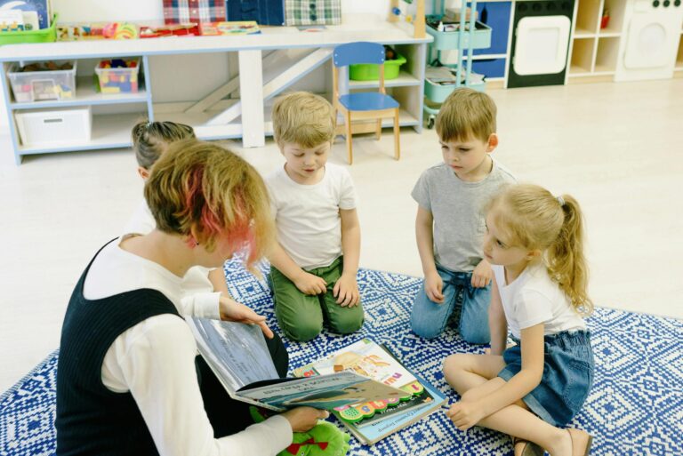 Group of children and a teacher reading together indoors at preschool.